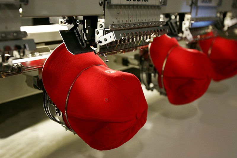 Tre cappelli rossi vengono ricamati su una macchina