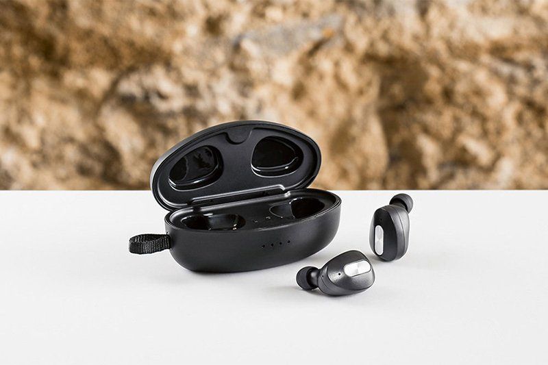 Un paio di auricolari wireless appoggiati su un tavolo bianco.