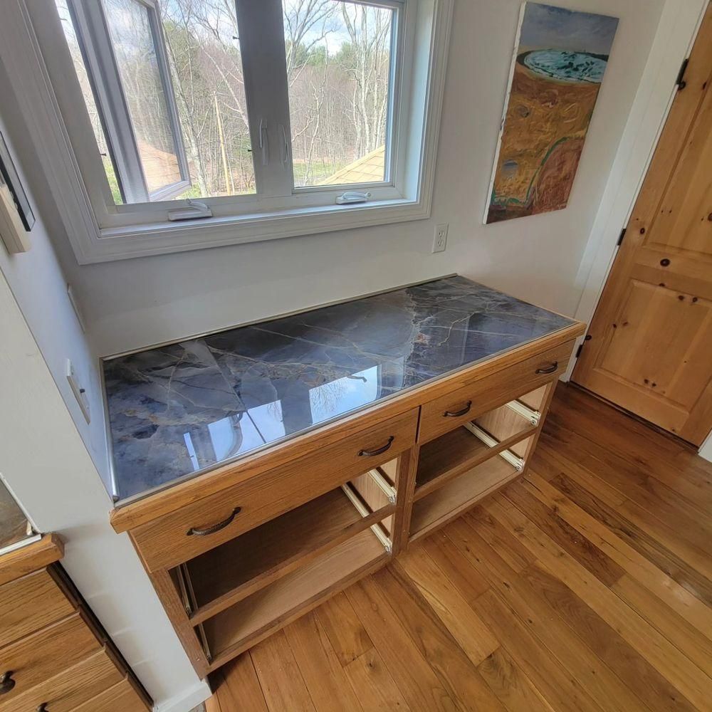 Wooden desk with marble top beneath a window in a bright room