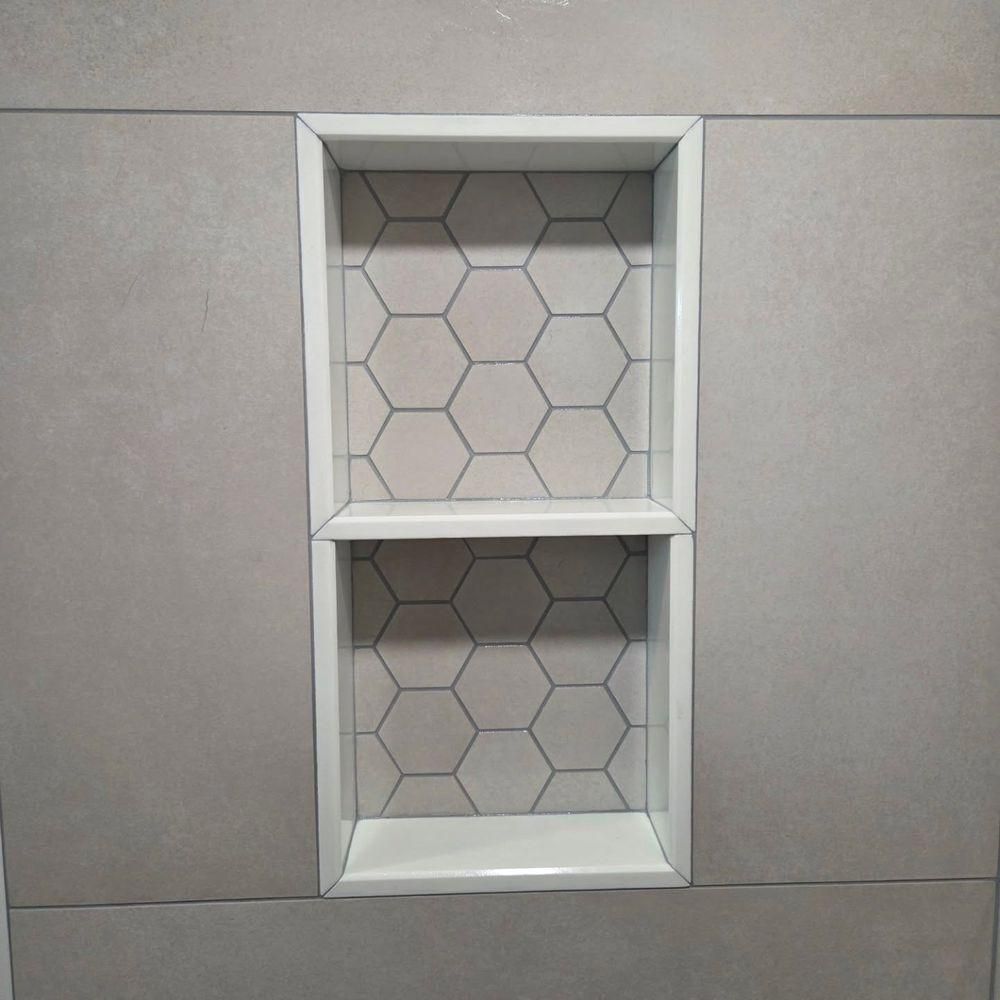White recessed wall shelf with two compartments and hexagon-patterned backing on a gray wall