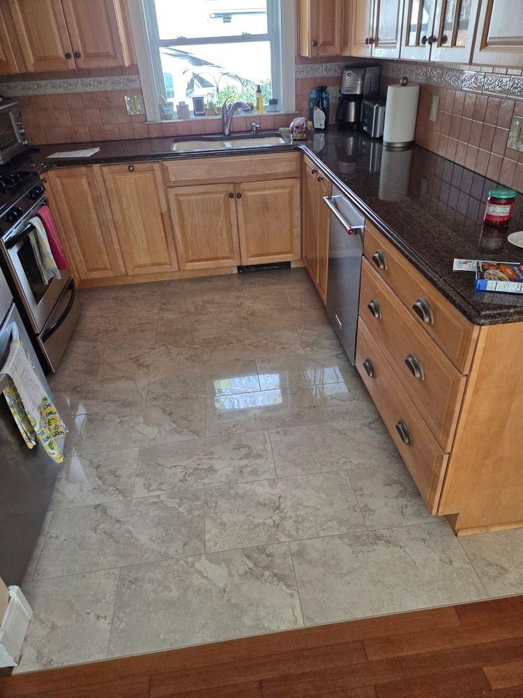 Empty kitchen with wood cabinets, tiled backsplash and stainless stove