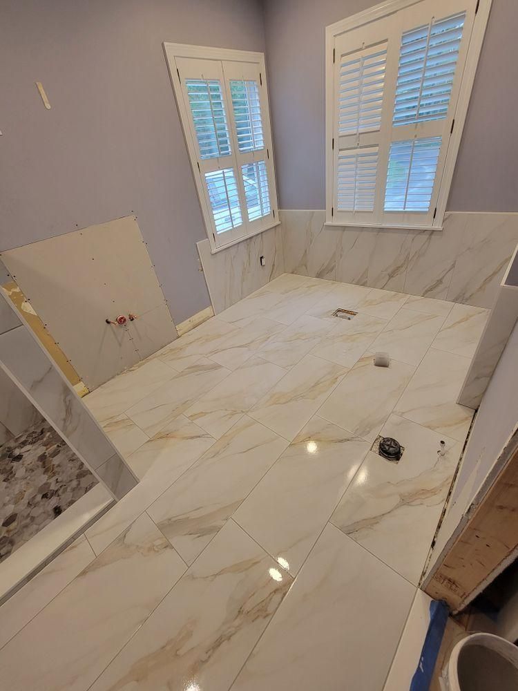 Luxury bathroom with white marble-look tile floor, marble vanity wall
