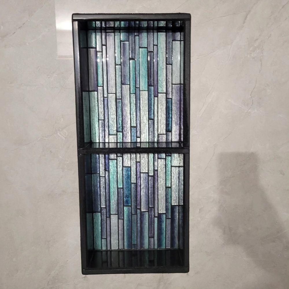 Rectangular wall art with blue, green, and white mosaic glass tiles in a black frame
