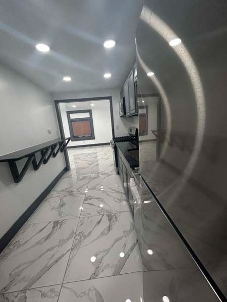 Modern hallway with glossy marble floor, black handrails, and recessed ceiling lights