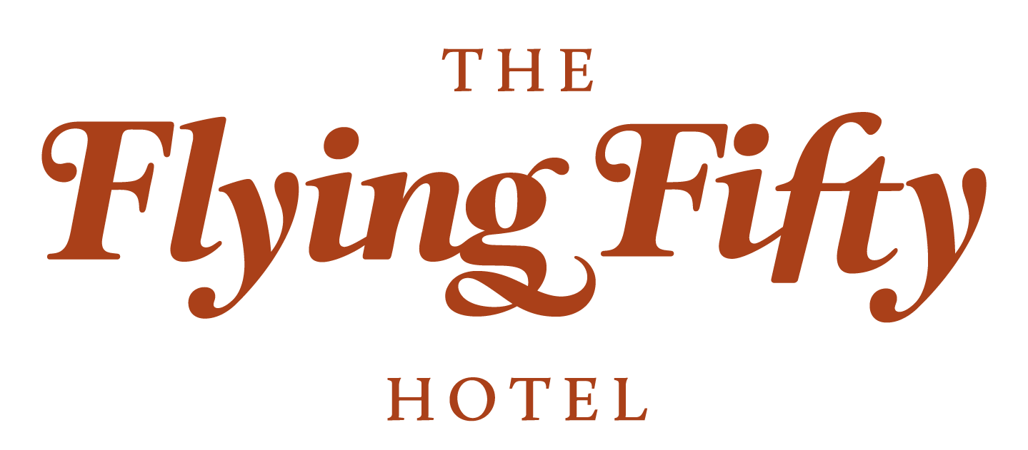 Logo for The Flying Fifty Hotel, featuring terracotta-colored serif text on a white background.