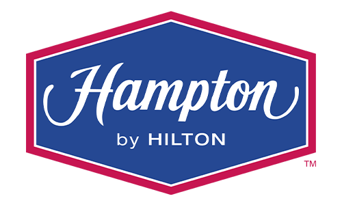 The logo for Hampton by Hilton, featuring white text inside a blue hexagon with a red border.