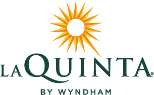 The La Quinta by Wyndham logo featuring a stylized yellow sun icon above dark green text.