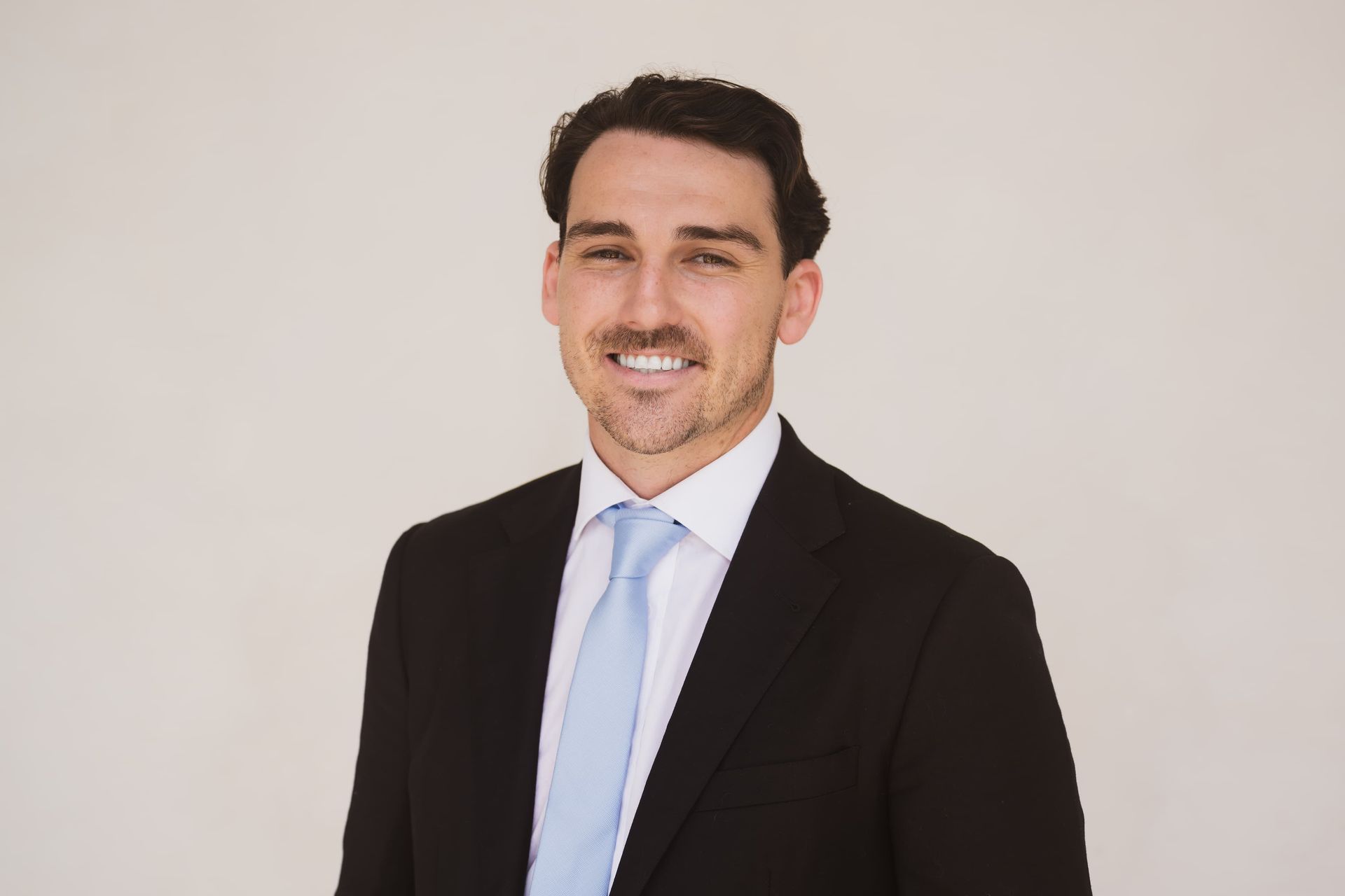 A man in a suit and tie is smiling for the camera.
