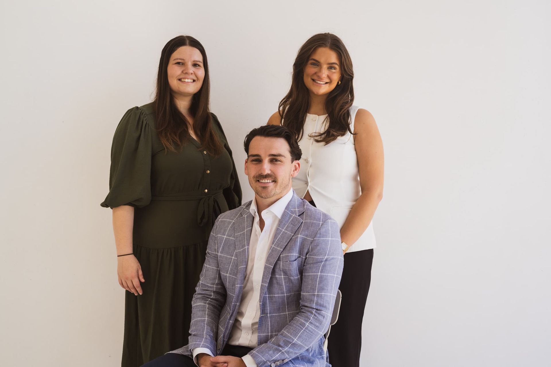 A man and two women are posing for a picture together.