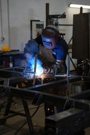 Un tecnico in tuta blu ispeziona i macchinari in un'officina di fabbrica.