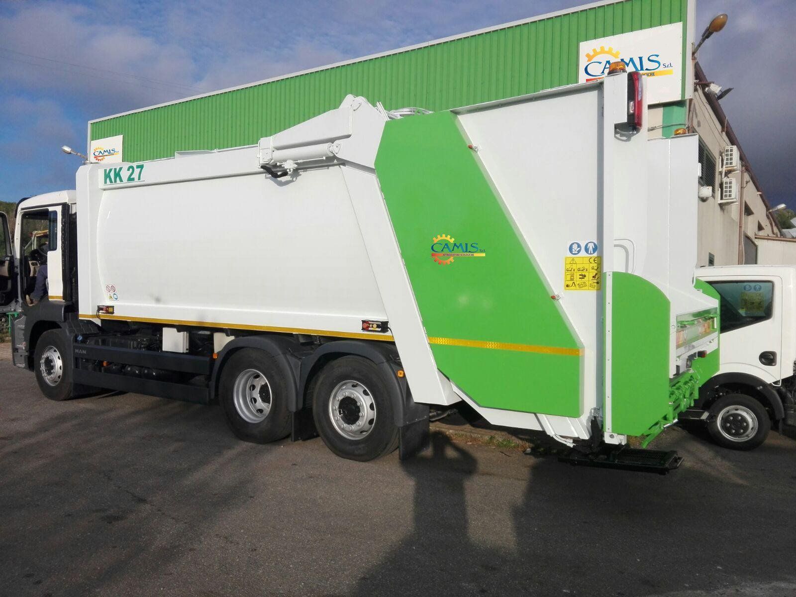 Camion della spazzatura verde e bianco parcheggiato in strada