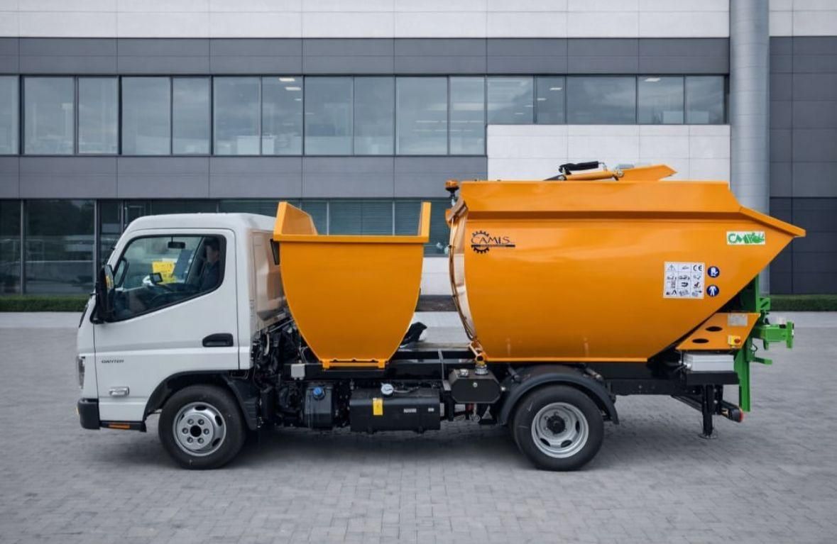 Camion della spazzatura bianco e arancione parcheggiato davanti a un edificio moderno
