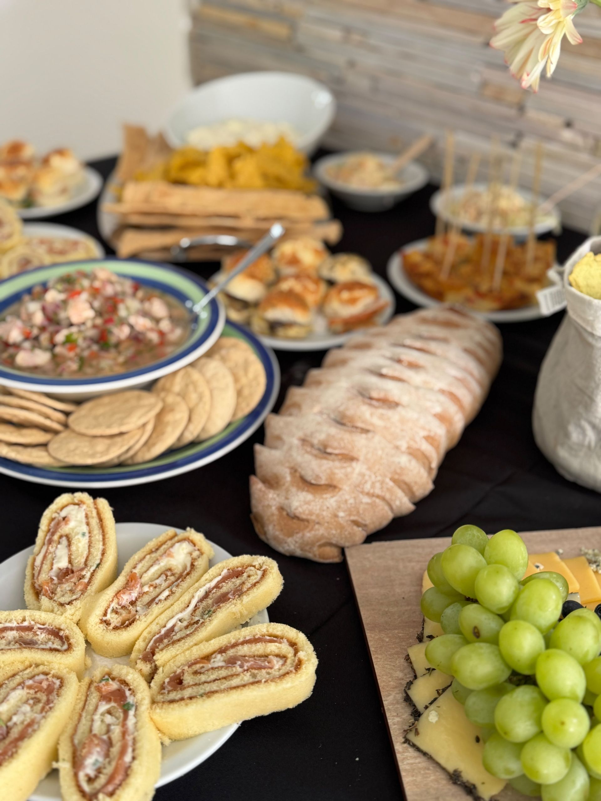 Pasteles variados, uvas y galletas saladas dispuestos en una mesa de bufé