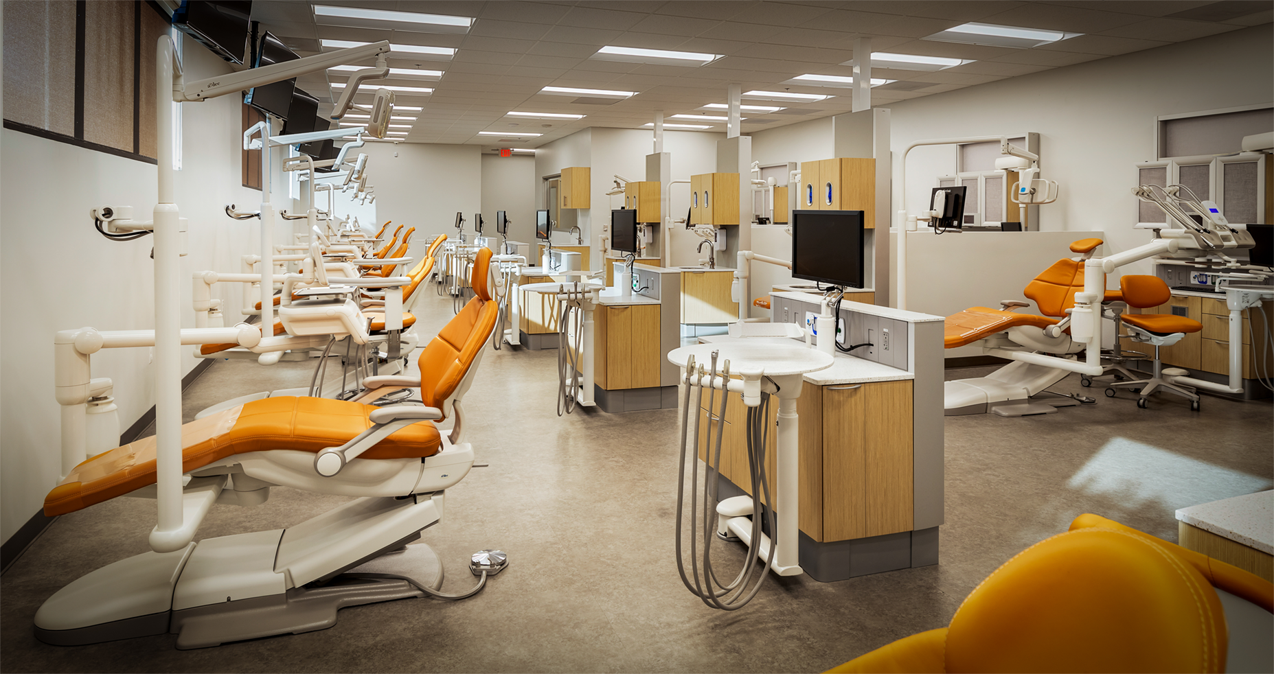 A dental office with a lot of dental chairs and equipment.