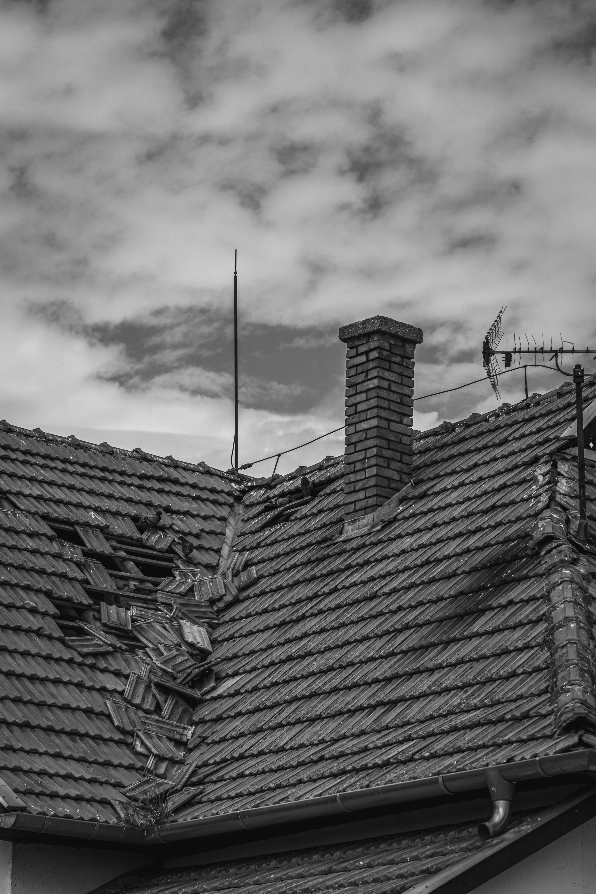 A black and white photo of a roof with a chimney on it.