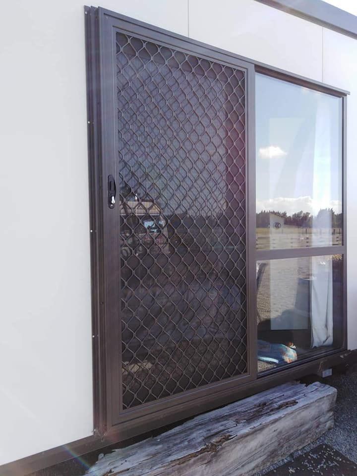 A sliding glass door with a chain link fence on the side of a building.