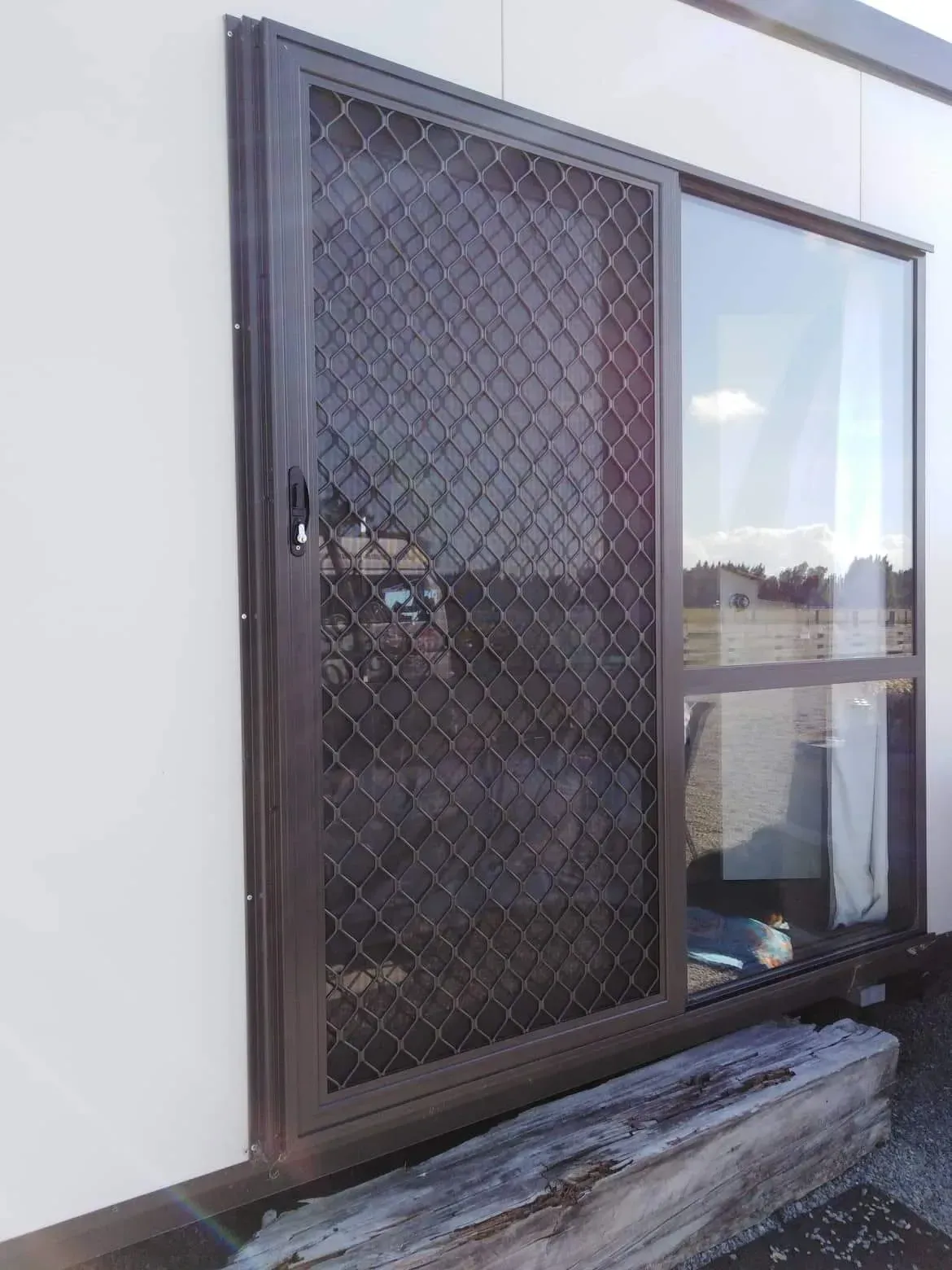 A sliding glass door with a chain link fence on it