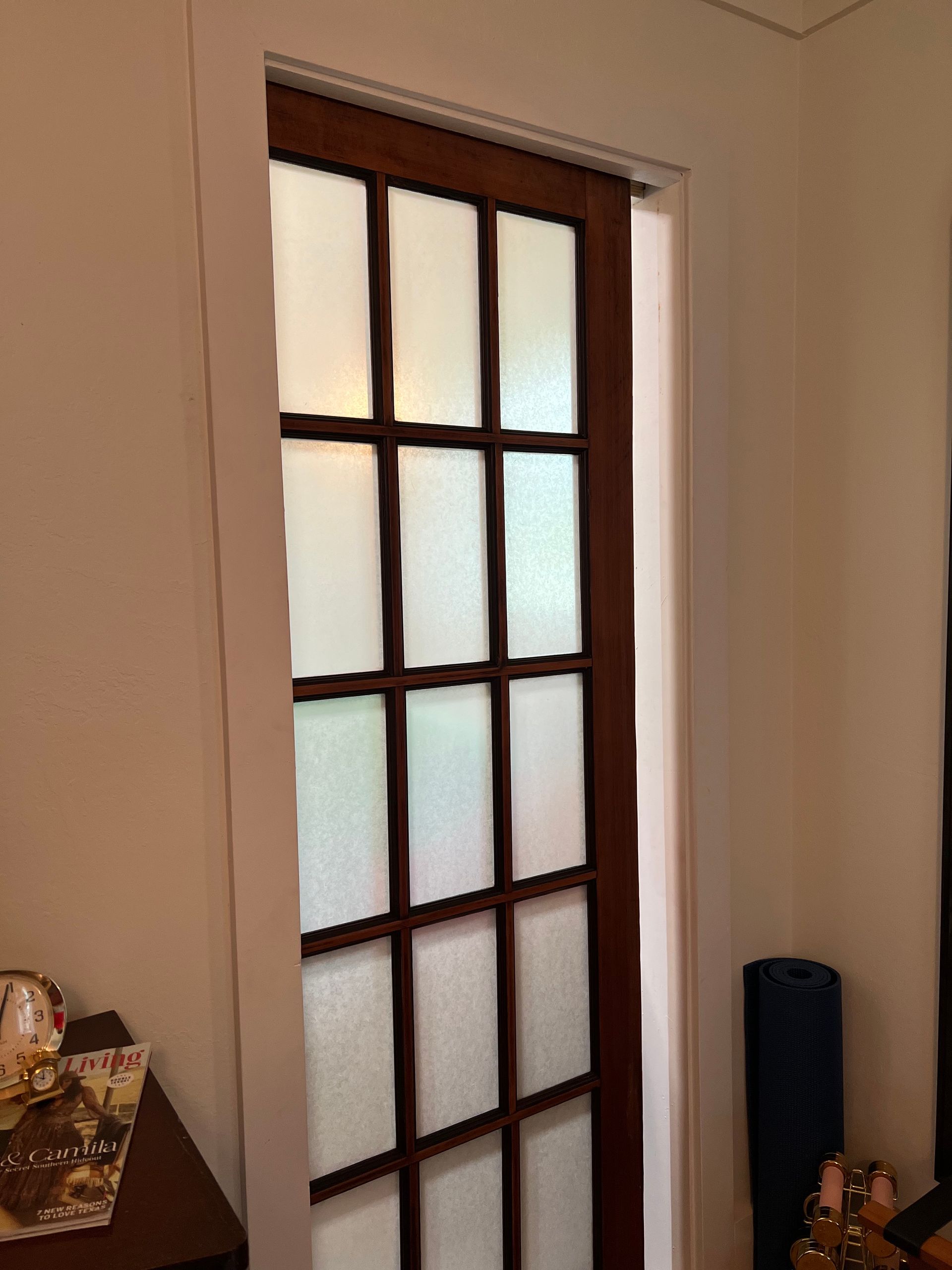 Wooden door with frosted glass panels, set in a white doorframe.