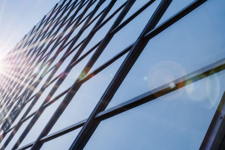 The sun is reflected in the windows of a tall building.