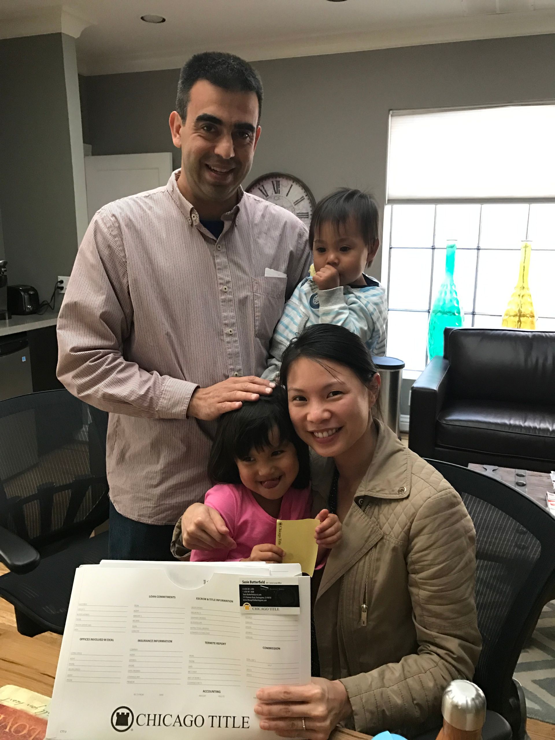 A family is posing for a picture in a living room.