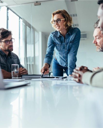 A group of people are sitting around a table having a meeting.