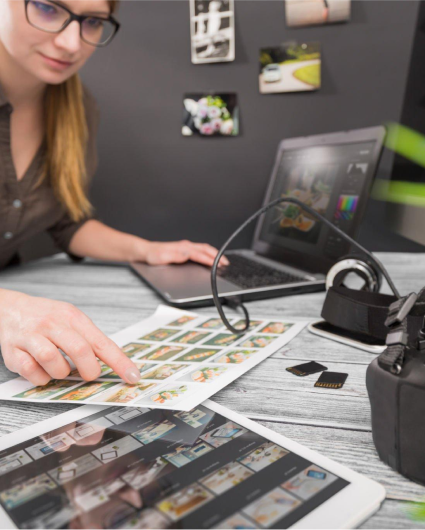 A woman is sitting at a desk looking at a tablet