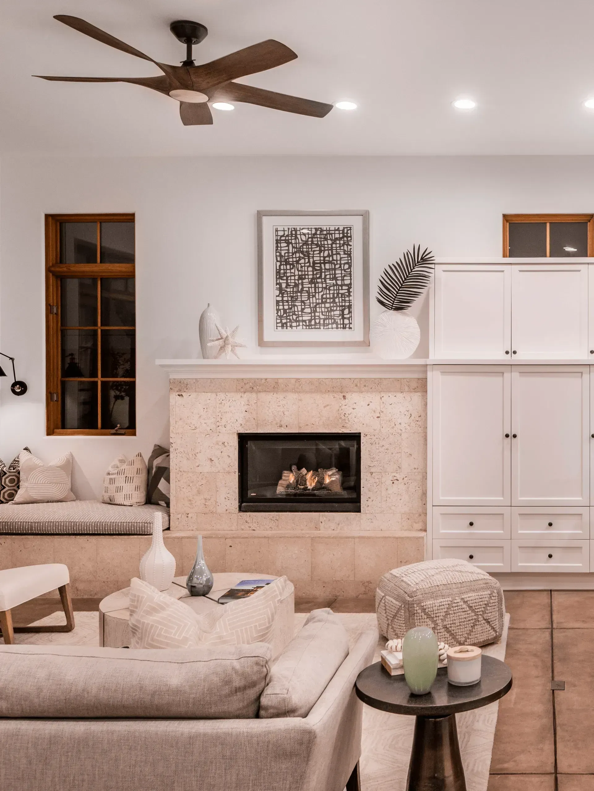 A living room with a fireplace and a ceiling fan