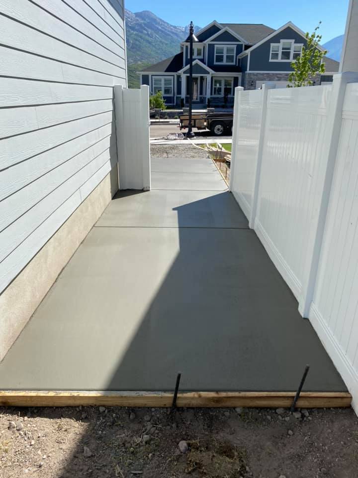 Side yard concrete extension around a gated fence