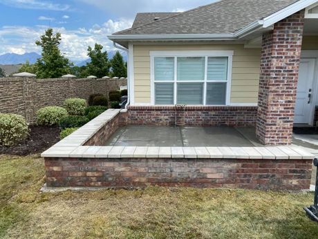 Concrete front porch extension on a brick and siding single family home