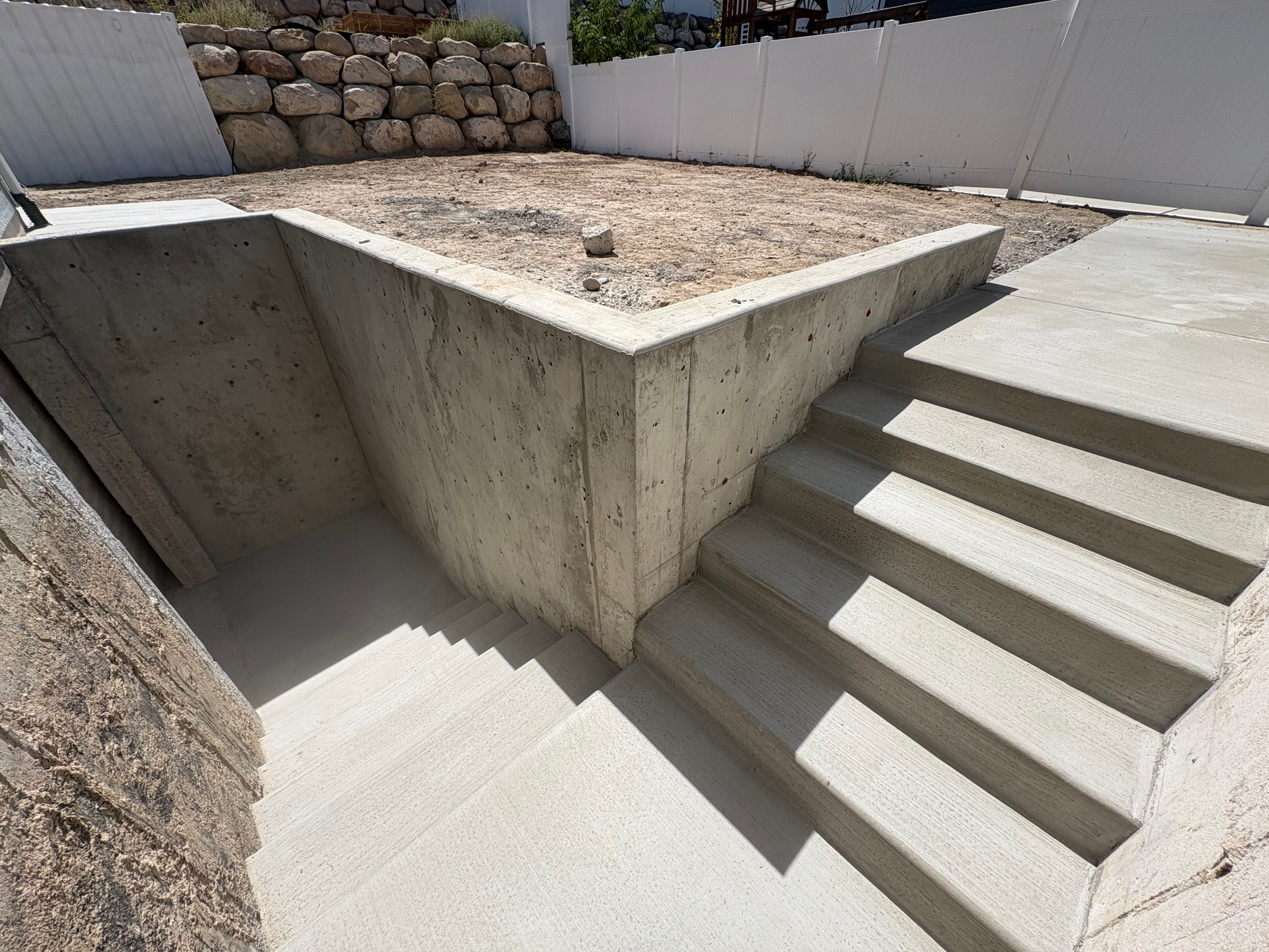 Concrete basement walkout entrance with two sets of stairs