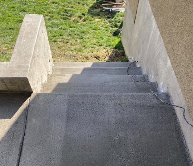 Concrete steps heading down to a backyard