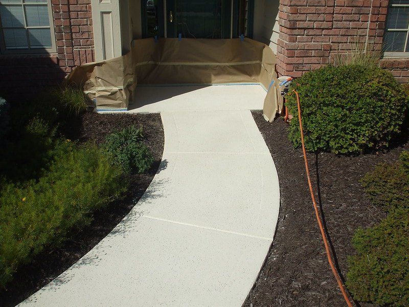 Concrete sidewalk connecting to a brick single family home