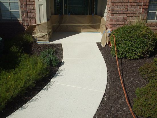 Concrete sidewalk connecting to a brick single family home