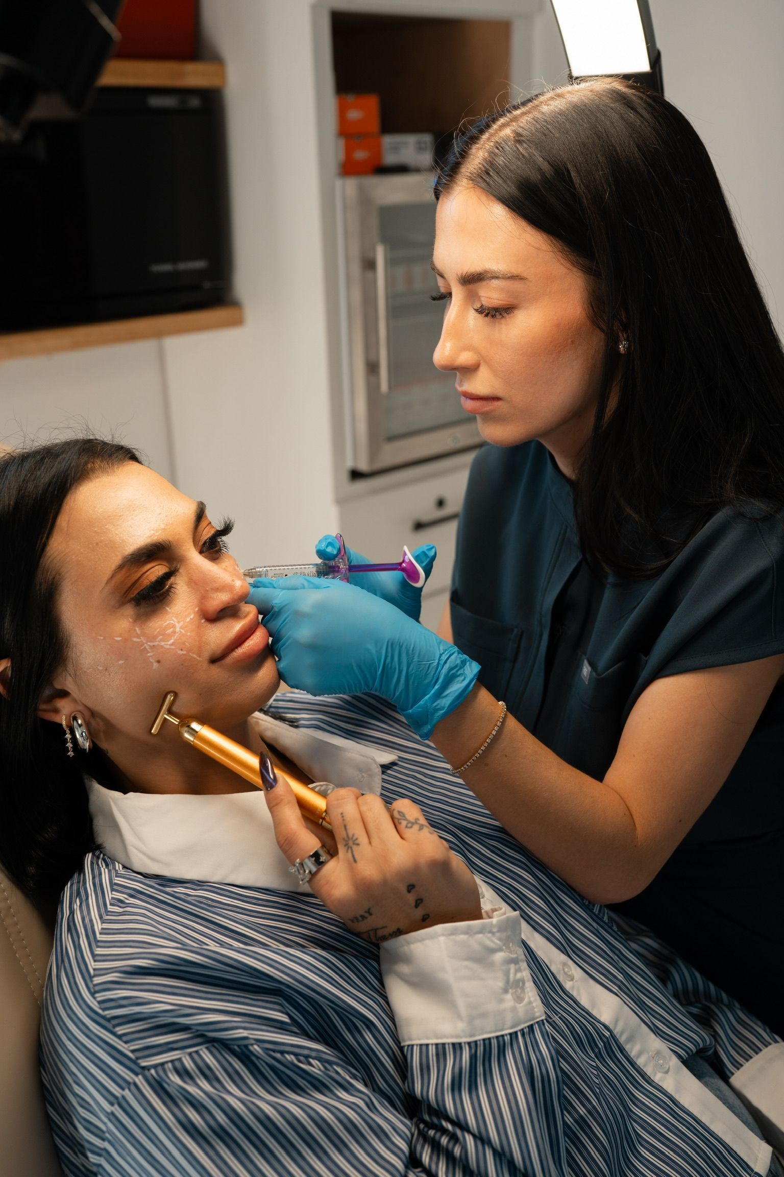 Person receiving cosmetic treatment from a professional in an office setting.