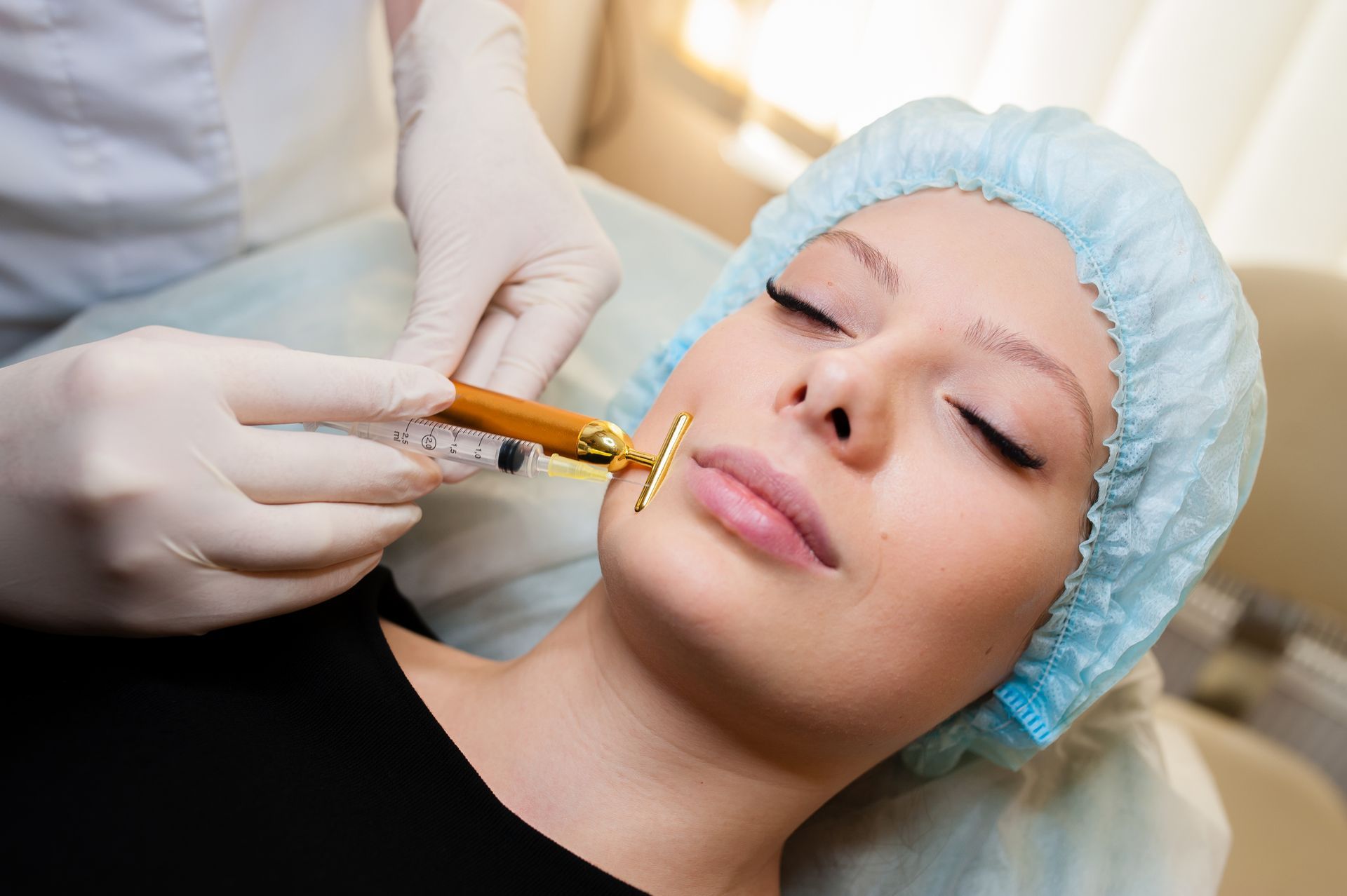 Gloved practitioner injects a woman’s cheek with a syringe during a cosmetic procedure