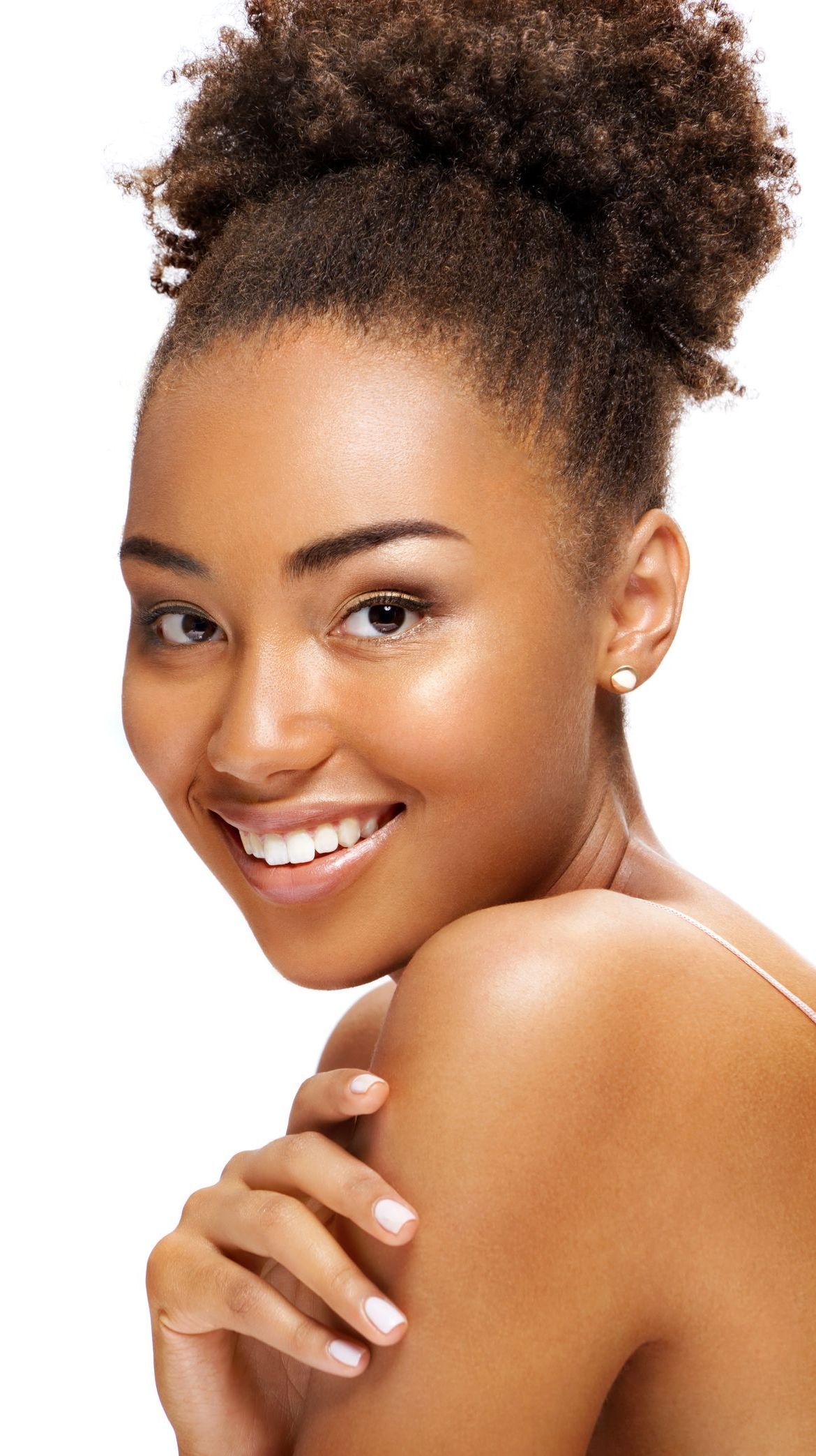 A woman with curly hair is smiling with her hand on her shoulder
