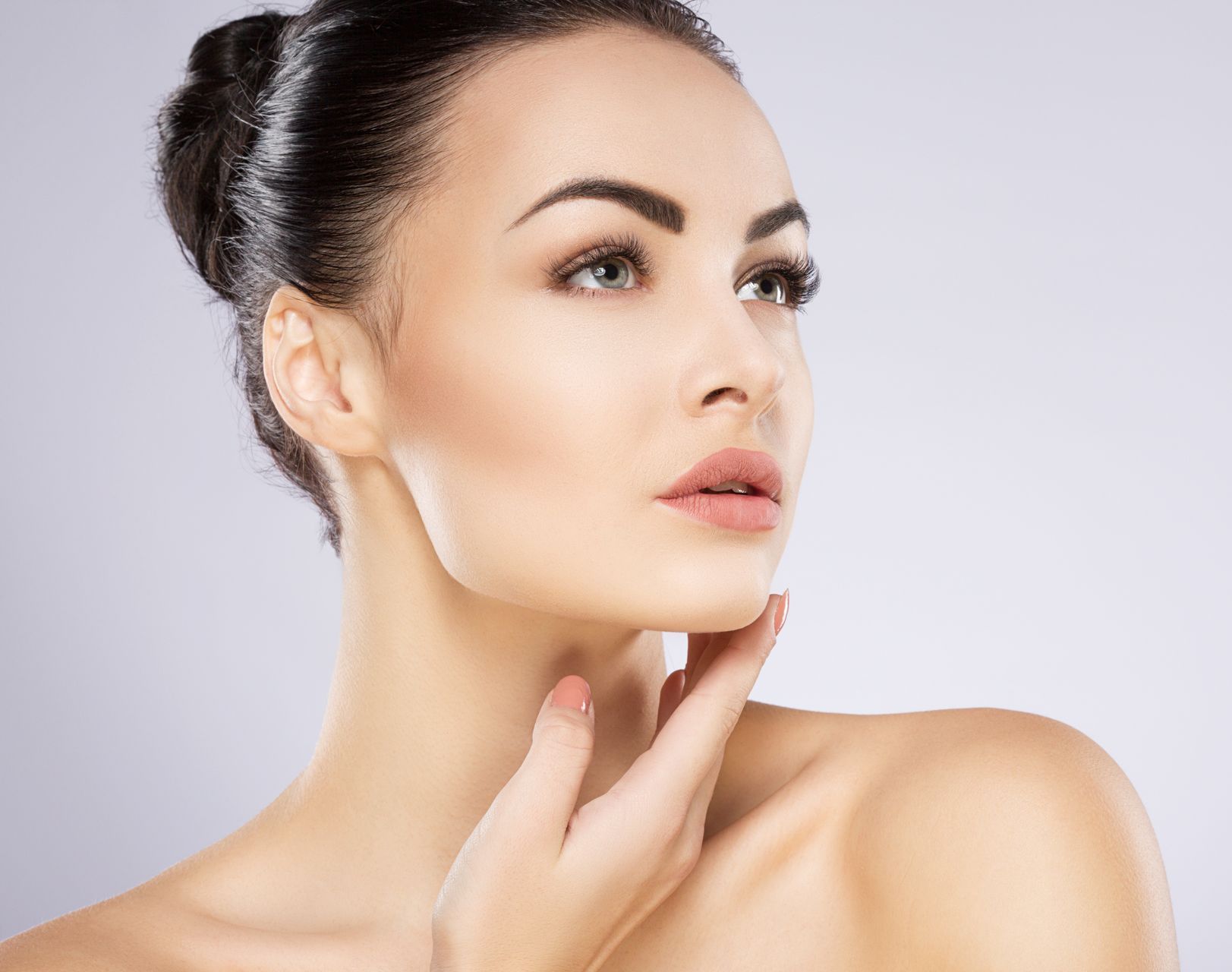 A close up of a woman 's face with her hand on her chin.