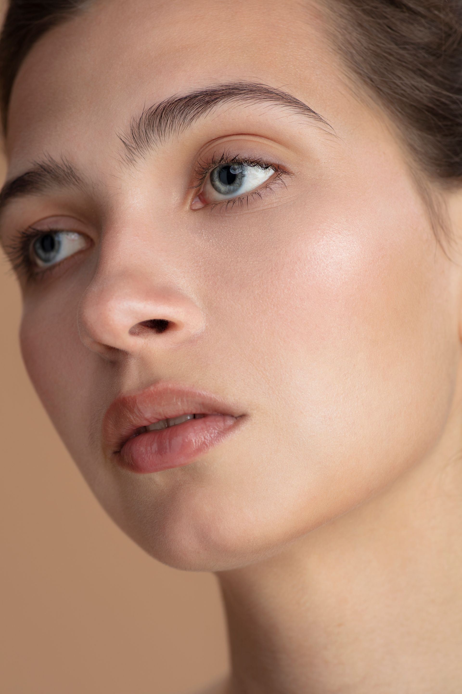 A close up of a woman 's face with blue eyes and freckles.
