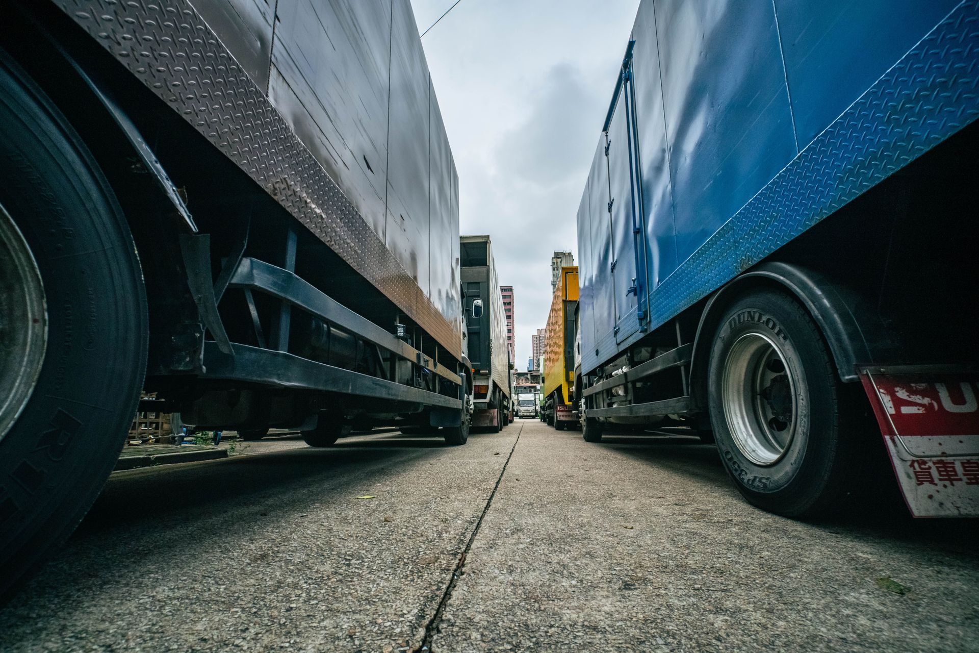 Vista desde un ángulo bajo entre dos camiones de carga estacionados en una calle.