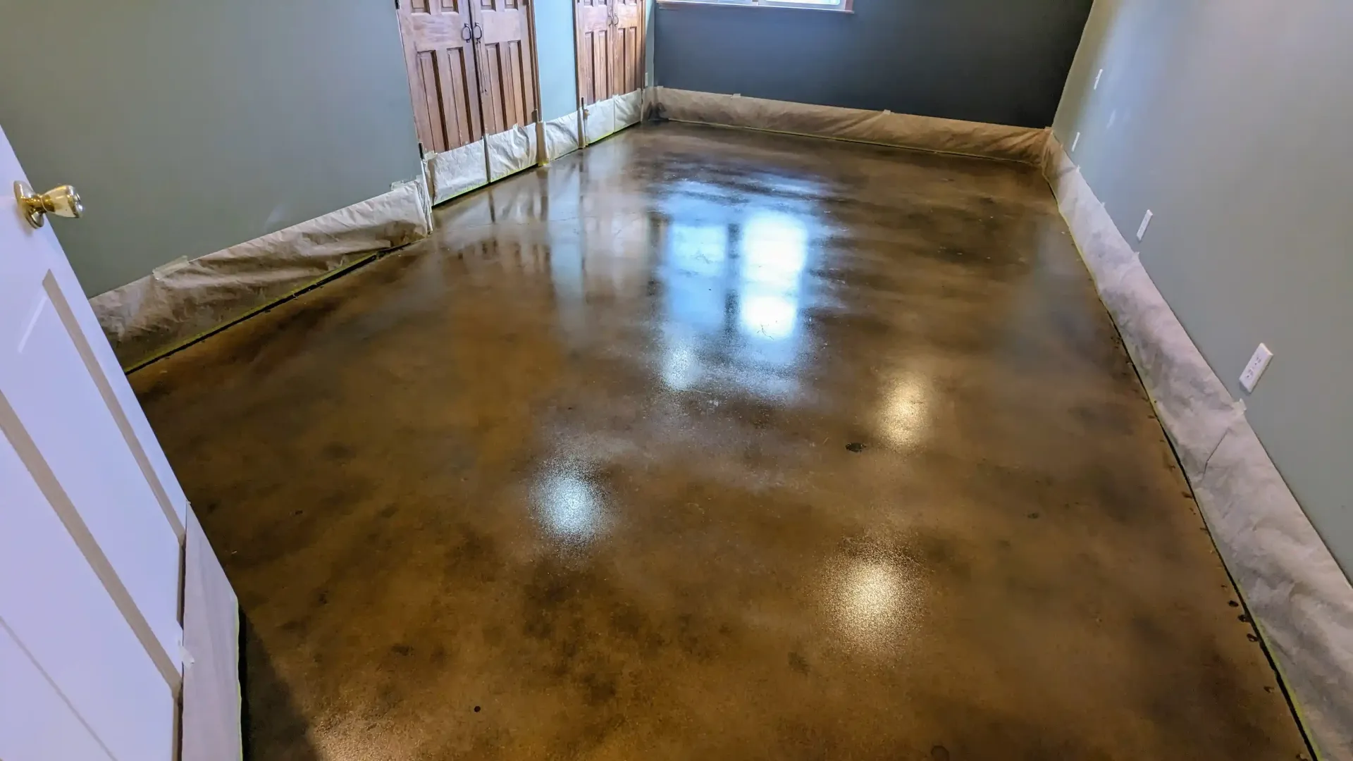 A large room with a wooden floor and a black wall.