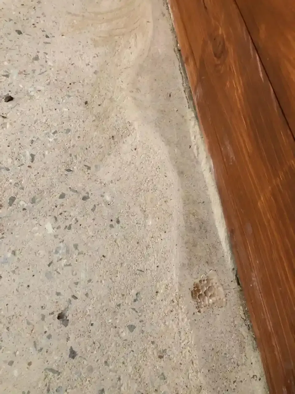 A close up of a concrete floor next to a wooden floor.