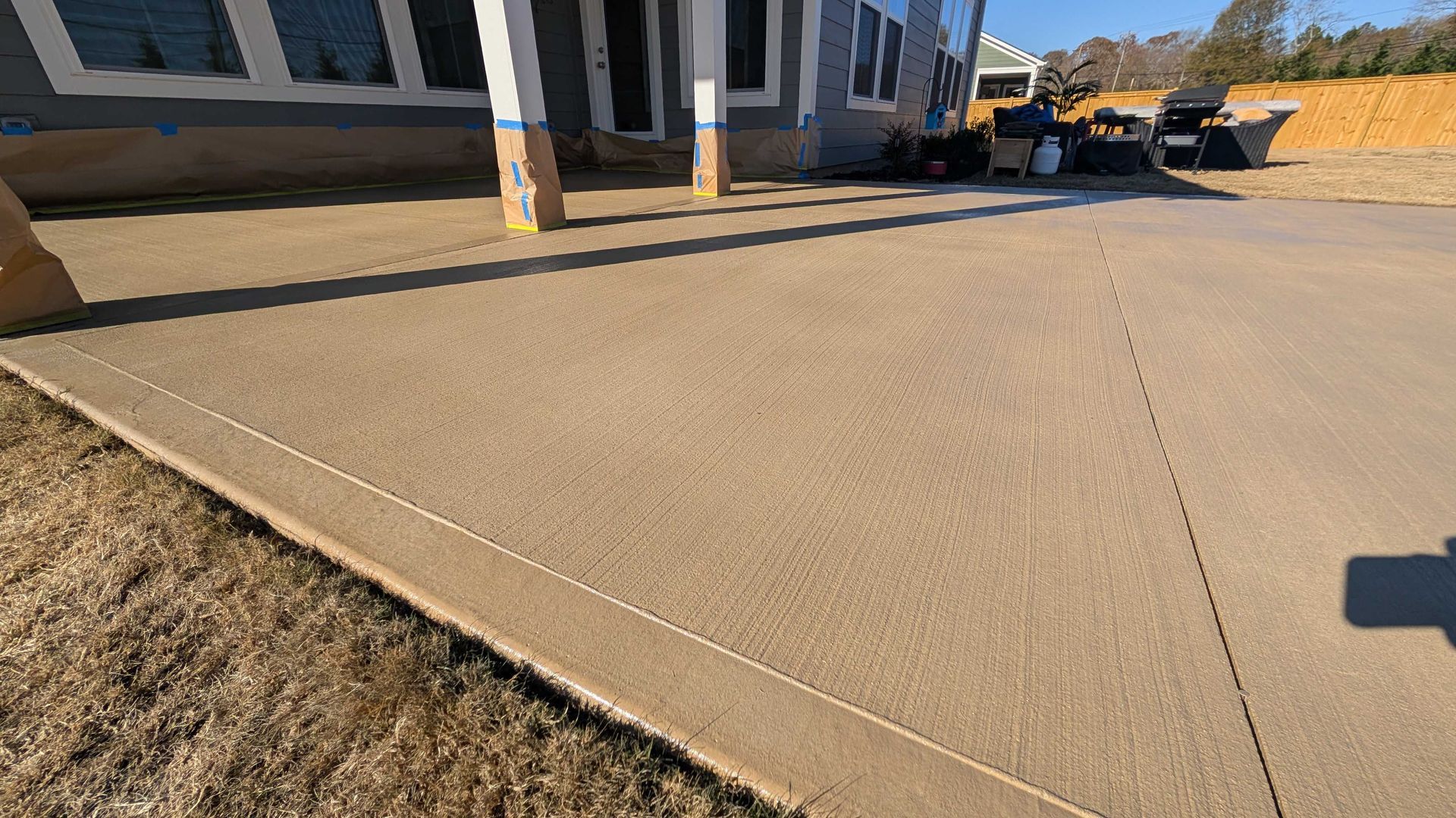 A concrete driveway in front of a house under construction.