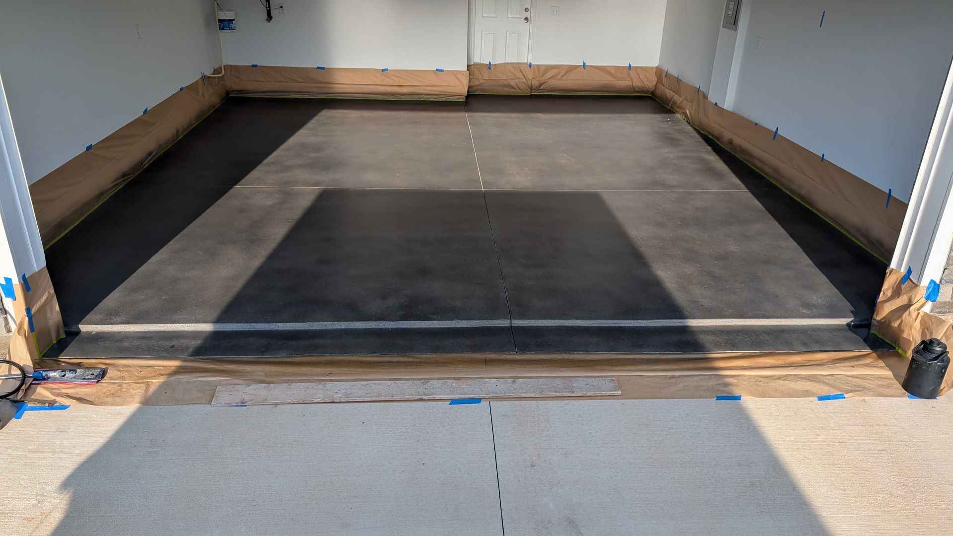 A concrete driveway is being built in front of a house.