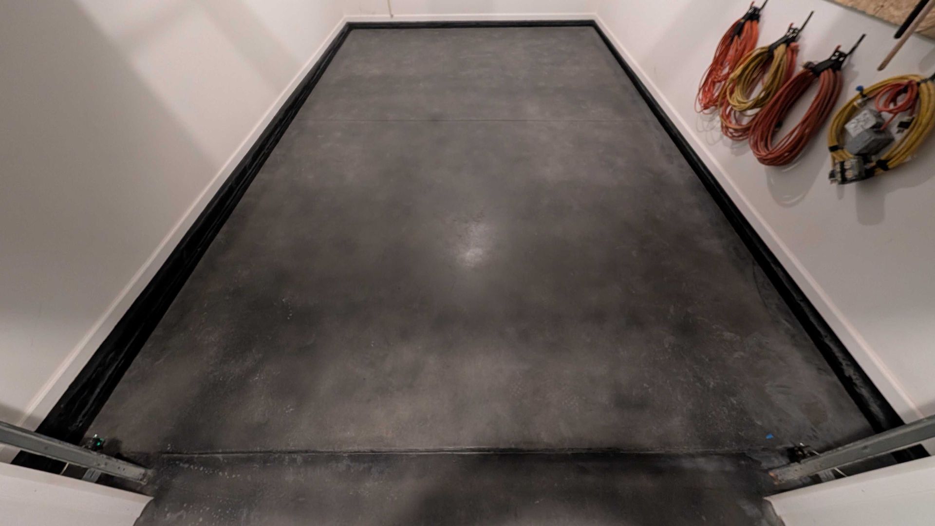 A black and white photo of a concrete floor in a room.
