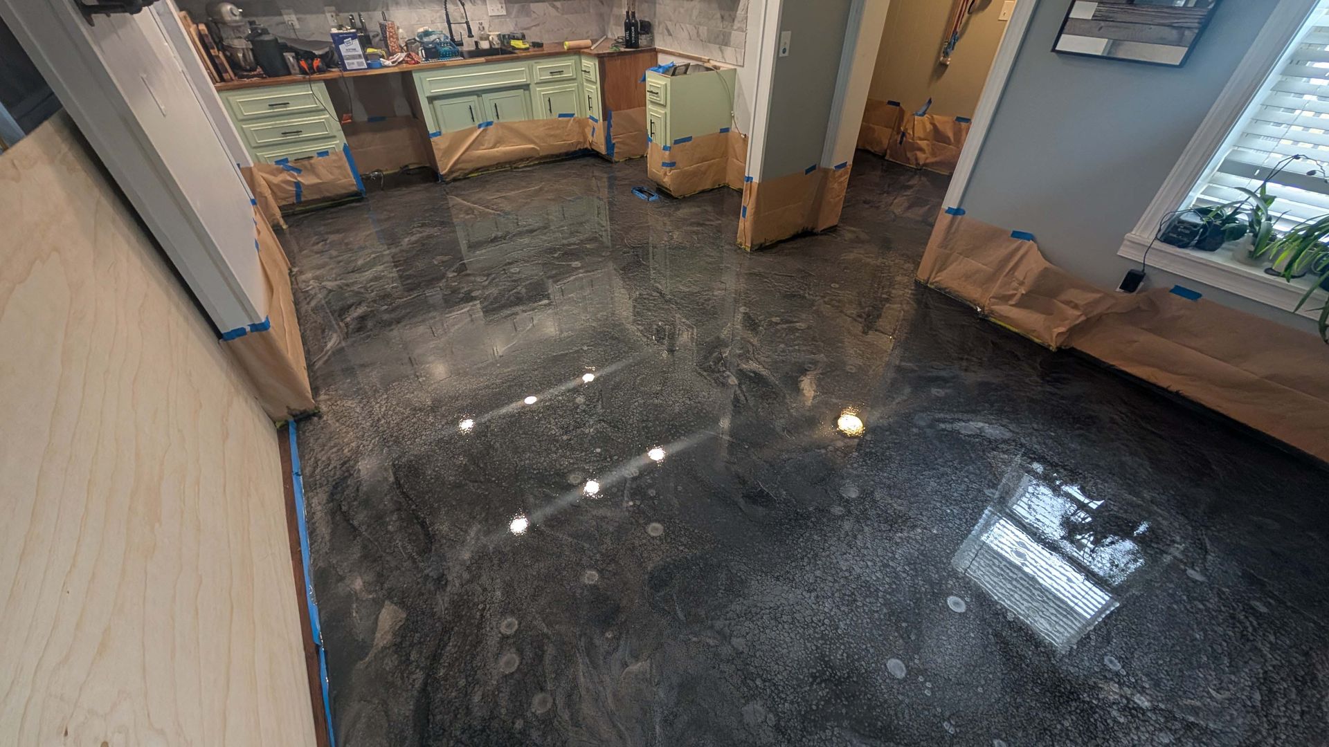 A kitchen with a shiny concrete floor and a bench.
