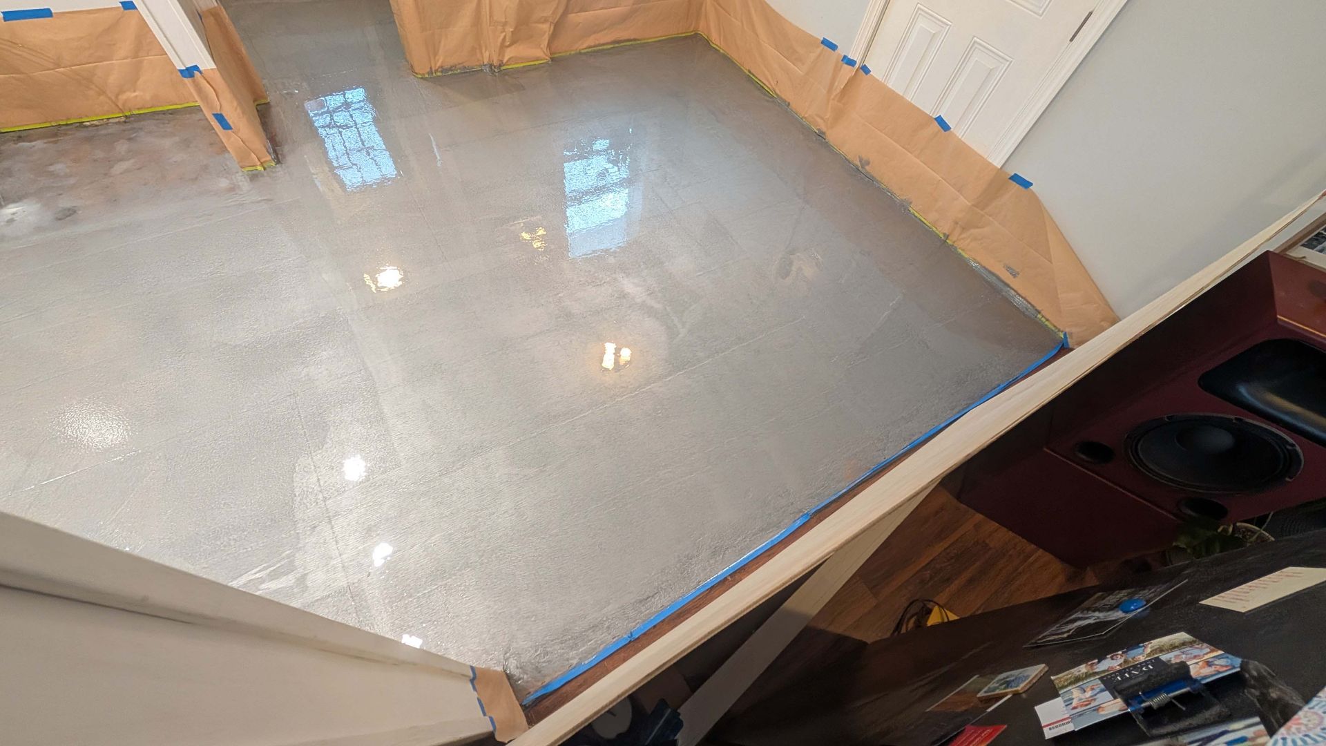 A collage of two pictures of a shiny metallic floor in a kitchen.