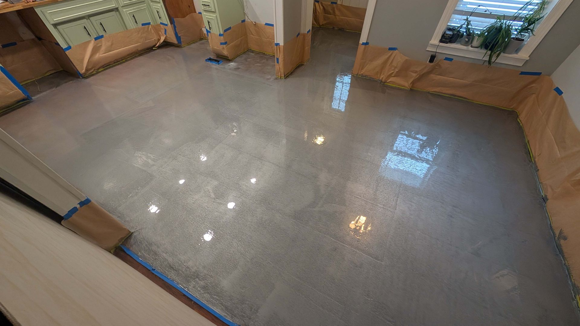 An aerial view of a kitchen with a shiny concrete floor.