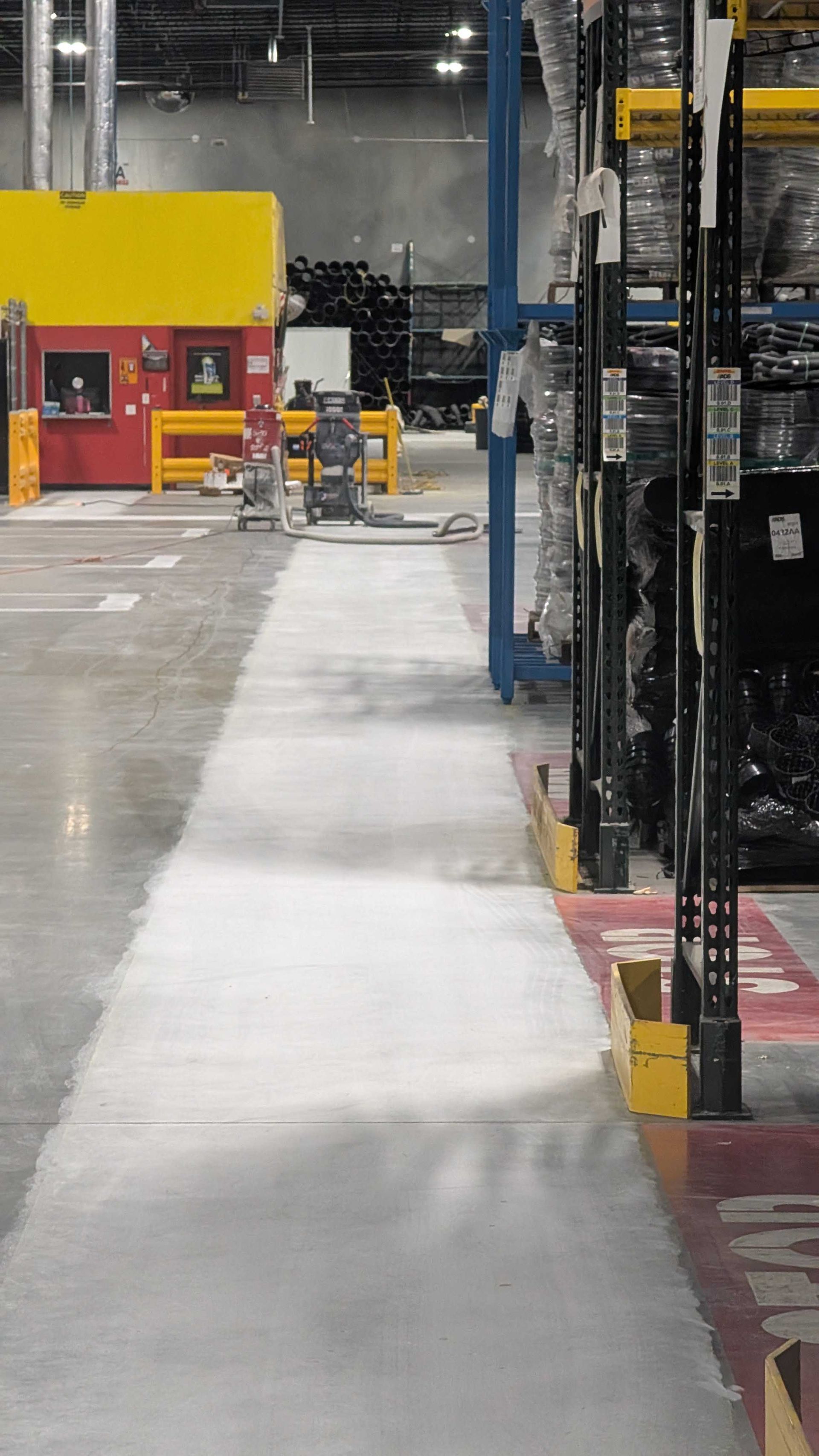 A warehouse with lots of shelves and a walkway between them.