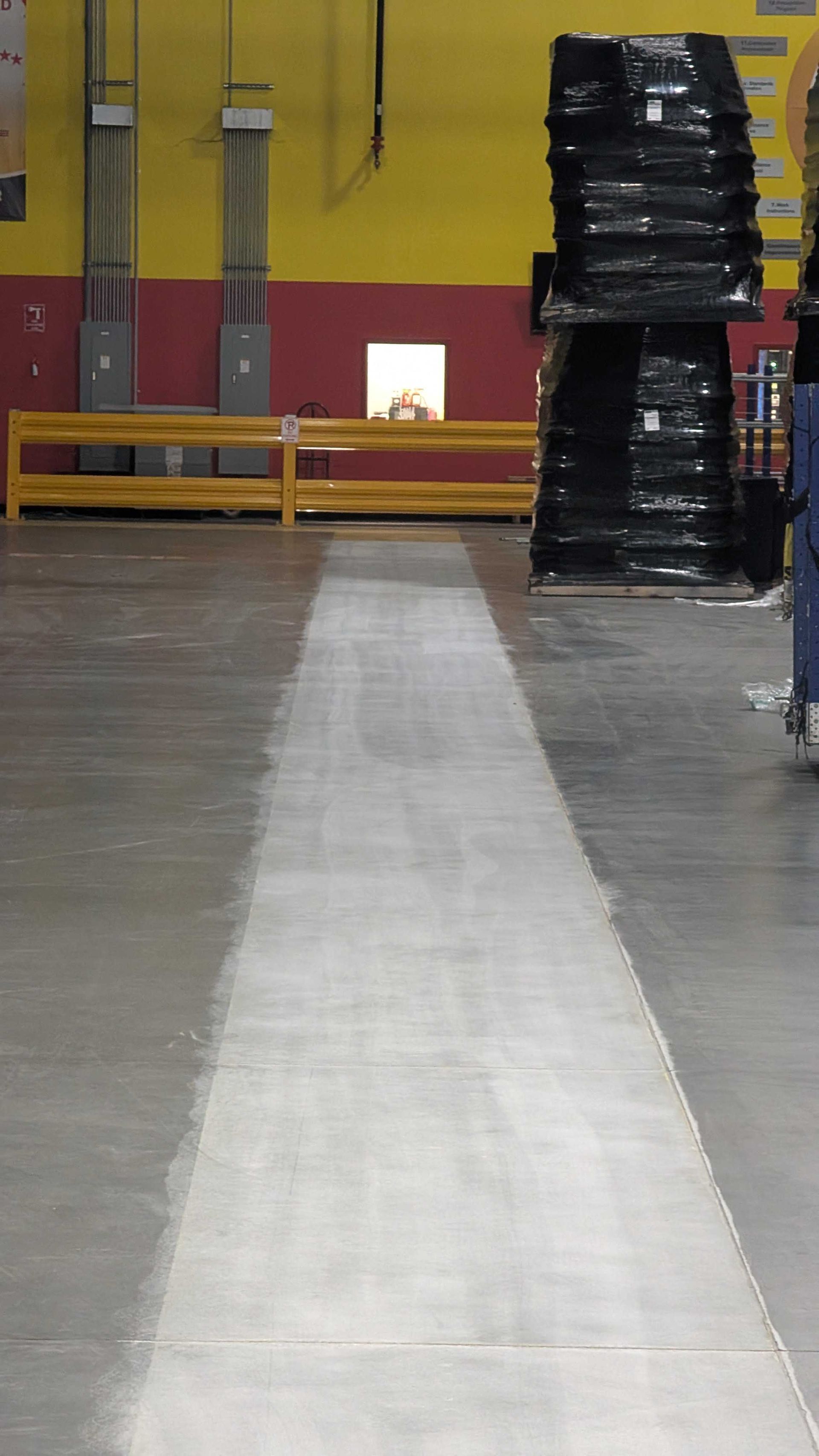 A warehouse with a lot of shelves and a white line on the floor.