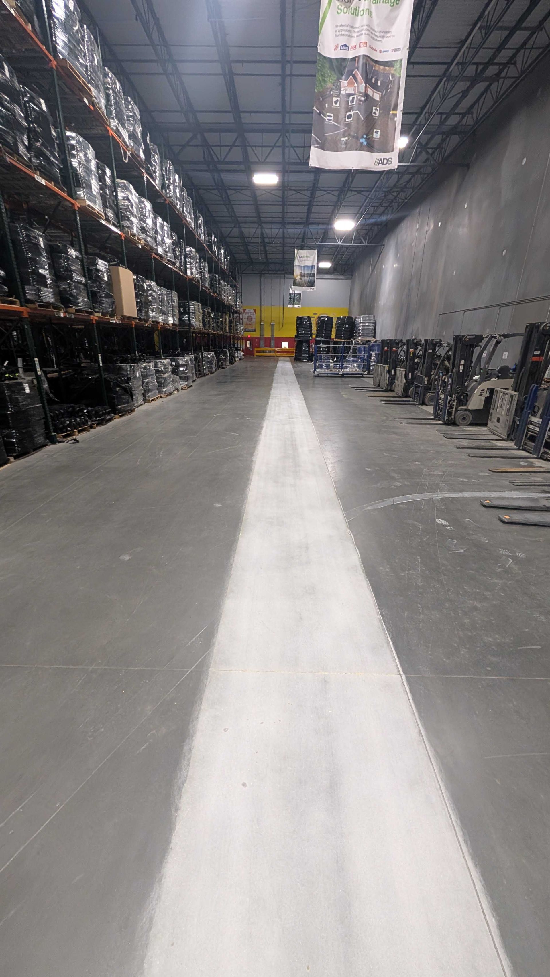 A warehouse with lots of shelves and a walkway between them.